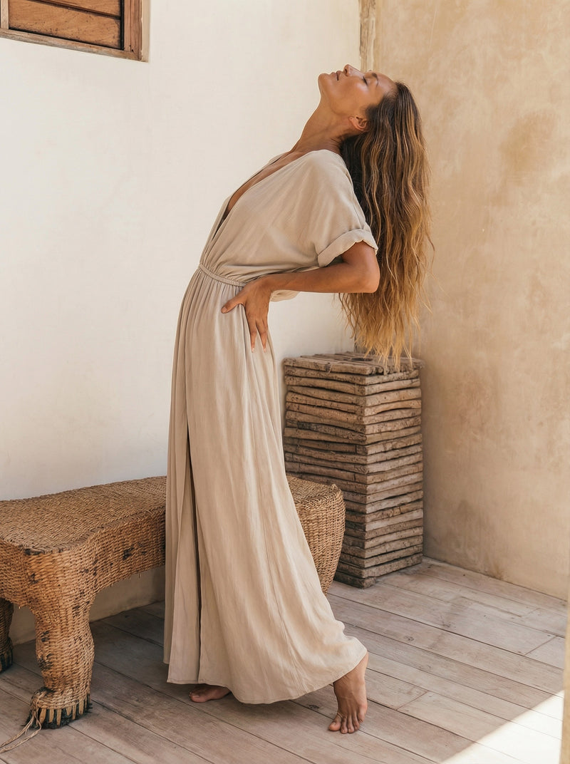Beden formunu nazikçe saran esnek belli ve yarasa kollu rahat yazlık bej rengi uzun elbise